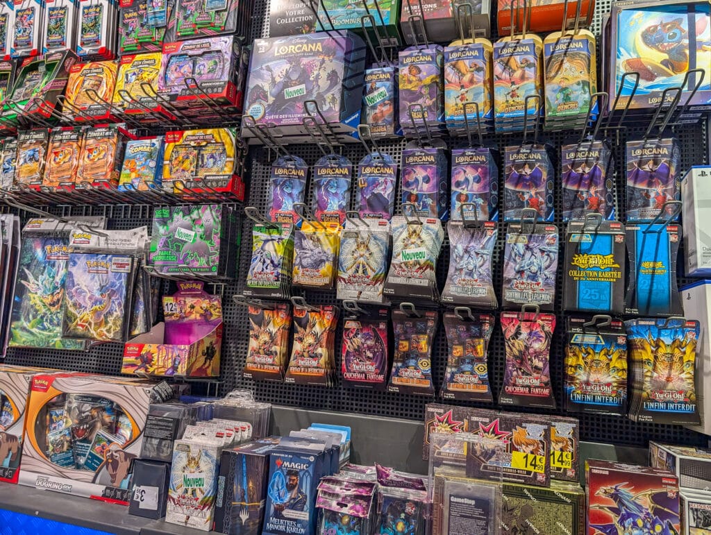Variety of trading card game packs on display shelf.